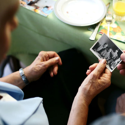 Elderly man holding a photo