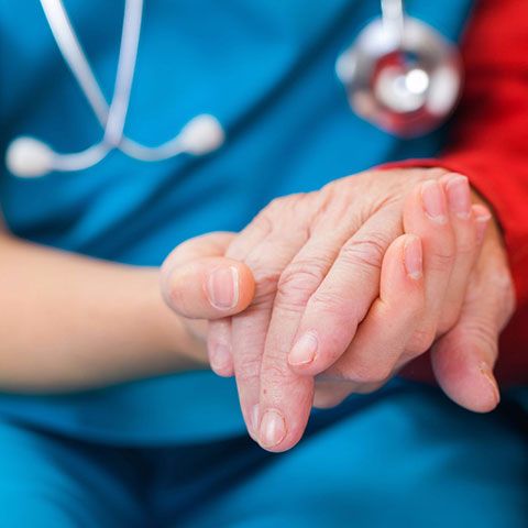 Nurse holding elderly patients hand