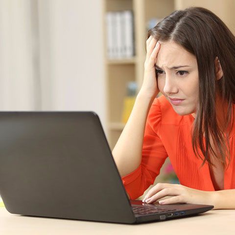 Lady looking unsure on a laptop