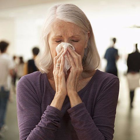 Elderly lady blowing her nose