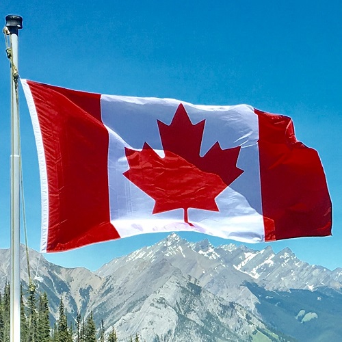 flag of canada flying over mountain